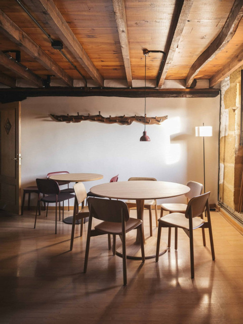 Cozy dining area with wooden tables and chairs at Wecamp San Sebastián, a holiday park in Basque Country.