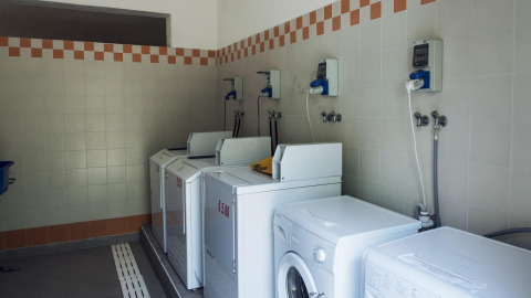Laundry room with several washing machines at Weekend Glamping Resort, a holiday park in Lombardy, Italy.