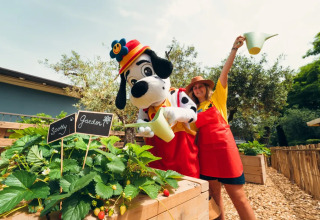Due persone, di cui una in costume da dalmata, annaffiano piante allo Spotty Garden del Weekend Glamping Resort in Lombardia.