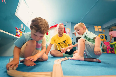 Kinder spielen mit einer Holzeisenbahn im Weekend Glamping Resort in der Lombardei, Italien.