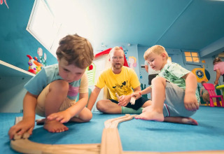 Kinder spielen mit einer Holzeisenbahn im Weekend Glamping Resort in der Lombardei, Italien.