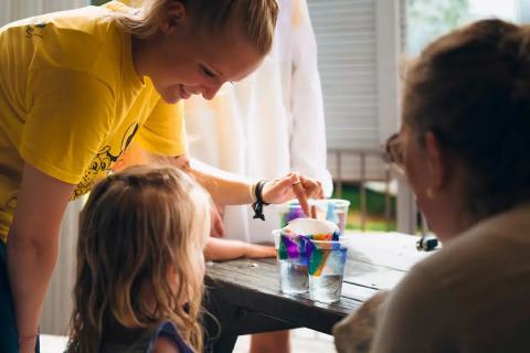 Kinder und Erwachsene führen ein buntes Wissenschaftsexperiment im Weekend Glamping Resort, Lombardei, Italien durch.