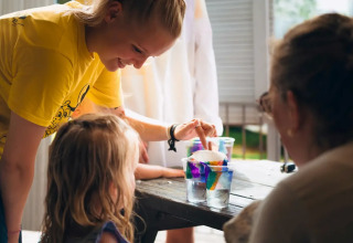 Kinder und Erwachsene führen ein buntes Wissenschaftsexperiment im Weekend Glamping Resort, Lombardei, Italien durch.