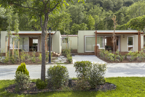 Vue extérieure des lodges Mobile home FAMILY, au design moderne avec terrasses et végétation luxuriante.