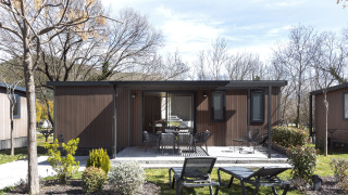 Casa móvil FAMILY XL lodge con terraza, muebles de exterior modernos, tumbonas y entorno ajardinado.