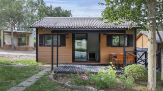 Acogedor bungalow de madera con porche cubierto, jardín y asientos en Bungalow BASIC FAMILY lodge.