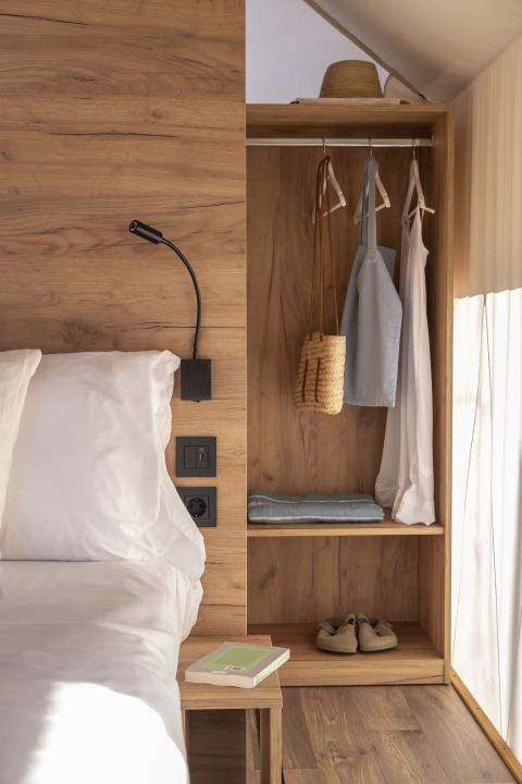 Interieur van Glamping Couple safaritent bij Wecamp San Sebastián, Spanje, met bed en open kast.