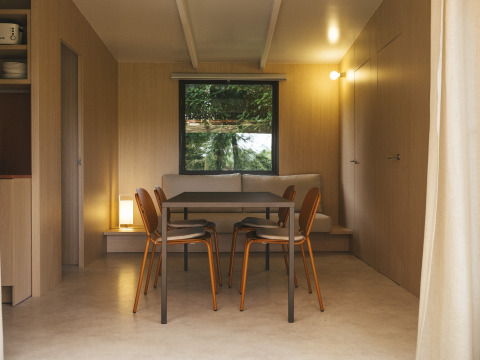 Eetruimte in Mobil Home Family Plus bij Wecamp San Sebastián, Spanje, met modern houten interieur.