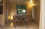 Comedor dentro del Mobil Home Family Plus en Wecamp San Sebastián, España, con interior moderno de madera.