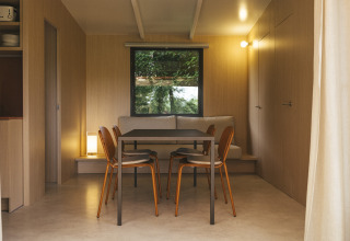 Eetruimte in Mobil Home Family Plus bij Wecamp San Sebastián, Spanje, met modern houten interieur.