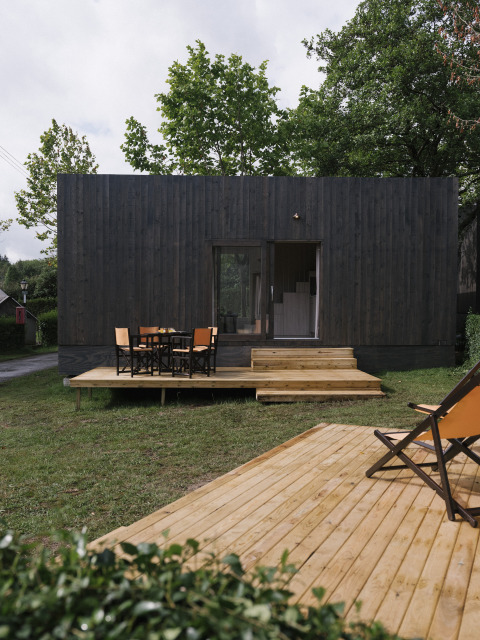 Tiny Home Family Wood, modern tiny house met houten terras, buitenzitje en een groene, rustige omgeving.