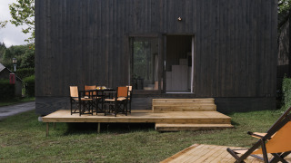 Tiny Home Family Wood, modern tiny house met houten terras, buitenzitje en een groene, rustige omgeving.