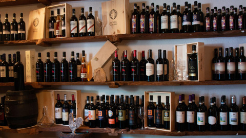 Bouteilles de vin et caisses en bois sur étagères au Vallicella Glamping Resort en Toscane, Italie.