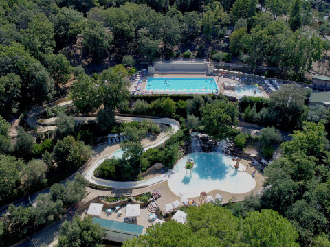 Vue aérienne du Vallicella Glamping Resort en Toscane, Italie, avec des piscines entourées de forêts.