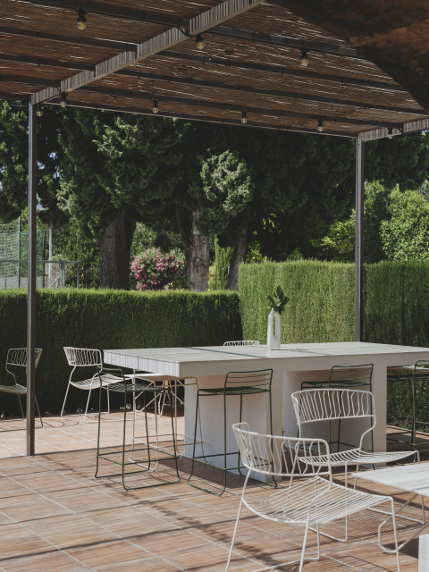 Udendørs terrasse på Wecamp Jávea i Valencia, Spanien, med moderne havemøbler og grønne omgivelser.