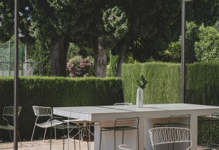 Terraza al aire libre en Wecamp Jávea, Valencia, España, con muebles modernos y vegetación frondosa.