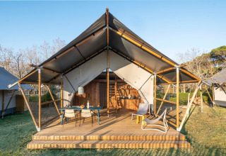 Tienda glamping en Wecamp Santa Cristina, Cataluña, España, con terraza de madera y muebles modernos.
