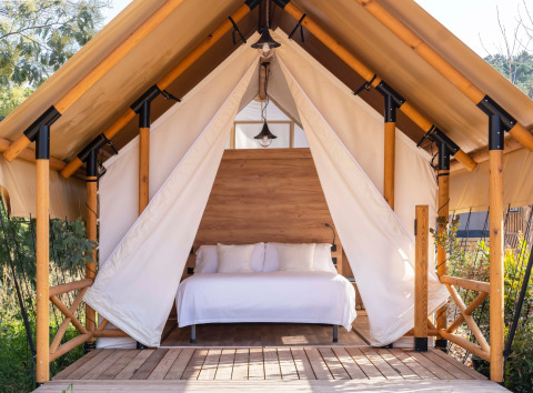 Et glamping-telt med træstruktur og seng, beliggende i Wecamp Santa Cristina i Catalonien, Spanien.