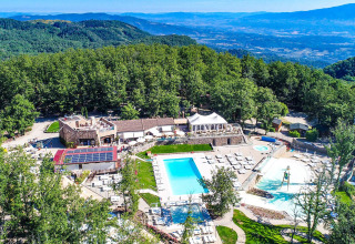 Luchtfoto van Chianti Glamping Resort in Toscane met zwembaden, groene natuur en prachtig heuvellandschap.