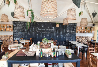 Ristorante accogliente con menù su lavagna e arredo rustico al Chianti Glamping Resort in Toscana, Italia.
