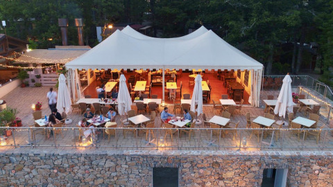 Buitenterras met wit tentdoek bij Chianti Glamping Resort in Toscane, Italië met tafels en stoelen.