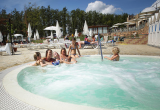 Gezinnen ontspannen in het bubbelbad bij Chianti Glamping Resort, een vakantiepark in Toscane, Italië.