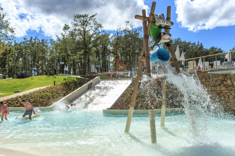 Kinderen spelen in waterpark met glijbanen en speelse figuren bij Chianti Glamping Resort, Toscane, Italië.