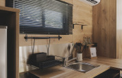Moderne kitchenette in TINY HOME FAMILY bij Wecamp Jávea, Spanje, met hout en zwarte accenten.
