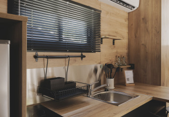 Moderne kitchenette in TINY HOME FAMILY bij Wecamp Jávea, Spanje, met hout en zwarte accenten.