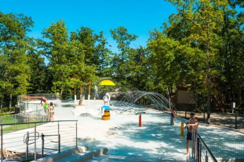 Wasserspielplatz im Chianti Glamping Resort in der Toskana, Italien, umgeben von grünen Bäumen.