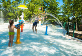 Kinder spielen im Wasserpark mit Springbrunnen im Chianti Glamping Resort in der Toskana, Italien.