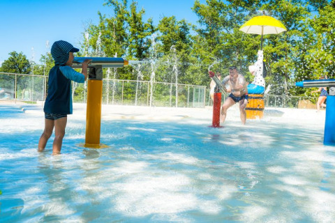 Niños y adultos disfrutan de los juegos de agua en Chianti Glamping Resort, un parque de vacaciones en la Toscana.