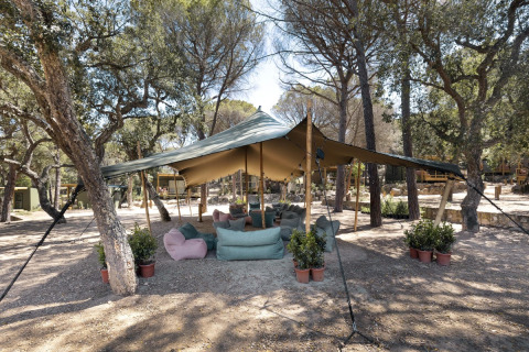 Gemütlicher Loungebereich unter Zeltdach im Wald bei Wecamp Santa Cristina in Katalonien, Spanien.