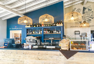 Inviting Italian café bar at Vacanze Glamping Boutique in Lombardy, Italy, with wicker lights and fresh pastries.