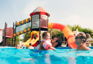 Family enjoying a pool with waterslide at Vacanze Glamping Boutique holiday park in Lombardy, Italy.