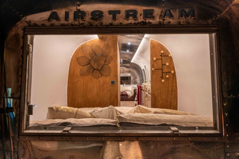 Uitzicht door het raam op het gezellige interieur van de Airstream tiny house bij Chianti Glamping Resort, Italië.