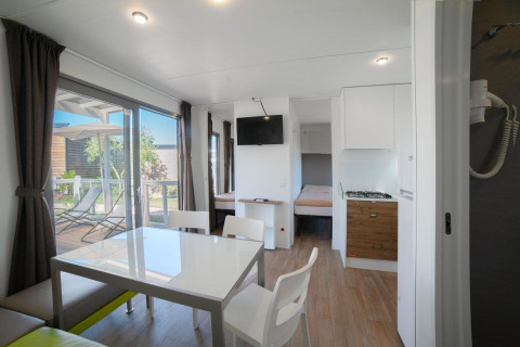 Bright, modern interior of Cottage Next XL Superior at Weekend Glamping Resort in Italy, with terrace view outside.