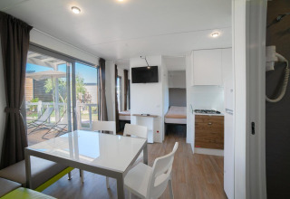 Bright, modern interior of Cottage Next XL Superior at Weekend Glamping Resort in Italy, with terrace view outside.