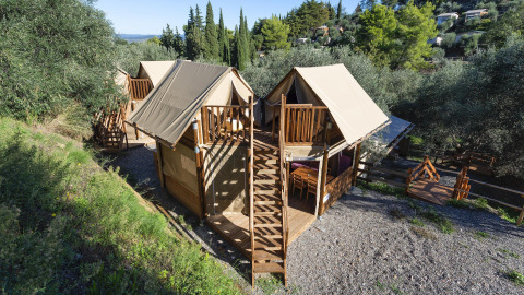 Luftaufnahme der Safari-Zelte Air Dreamer 2 mit Holzterrassen in einer grünen, bewaldeten Umgebung.