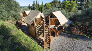 Vue aérienne des tentes safari Air Dreamer 2 avec terrasses en bois, situées dans un cadre verdoyant boisé.