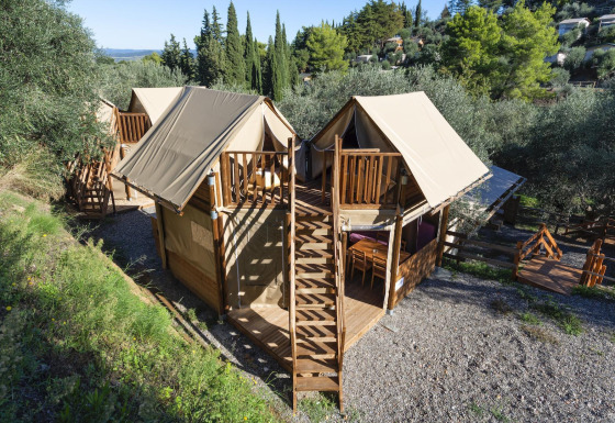 Luftaufnahme der Safari-Zelte Air Dreamer 2 mit Holzterrassen in einer grünen, bewaldeten Umgebung.