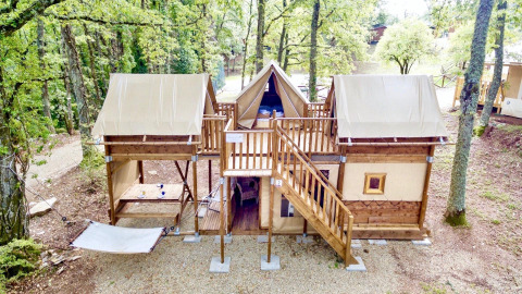 Safari-Zelt Air Dreamer 3 im Wald mit Holzstruktur, zwei Ebenen und einer Hängematte im Freien.