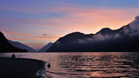 Tramonto sul lago a Lago Idro Glamping Boutique, Lombardia, Italia, con montagne sullo sfondo.