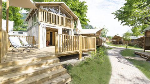 Buitenzicht op houten chalets en wandelpad bij Lago Idro Glamping Boutique, Lombardije, Italië.