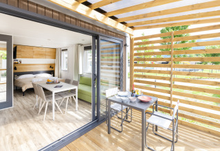 Interni luminosi e terrazza della Cube Suite XL al Lago Idro Glamping Boutique, Italia, con zona pranzo.
