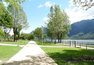 Parkpad met zicht op het meer en de bergen bij Lago Idro Glamping Boutique, Lombardije, Italië, op een zonnige dag.
