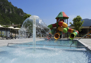 Parque acuático infantil con toboganes y fuente en Lago Idro Glamping Boutique, Lombardía, Italia.