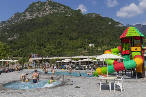 Piscine extérieure avec toboggan coloré et vue sur la montagne au Lago Idro Glamping Boutique en Italie.