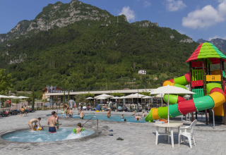Udendørs poolområde med vandrutsjebane og bjergrig baggrund på Lago Idro Glamping Boutique i Italien.