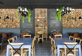 Intérieur de restaurant moderne au Lago Idro Glamping Boutique, Lombardie, Italie, avec murs en bois et menus.